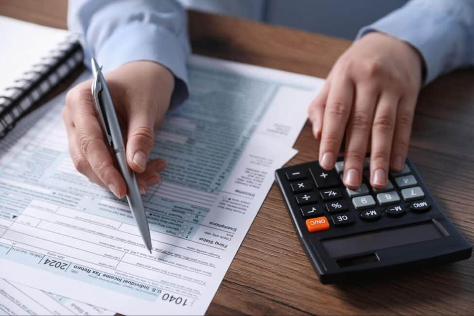 Woman using a calculator to file her taxes as soon as tax season starts