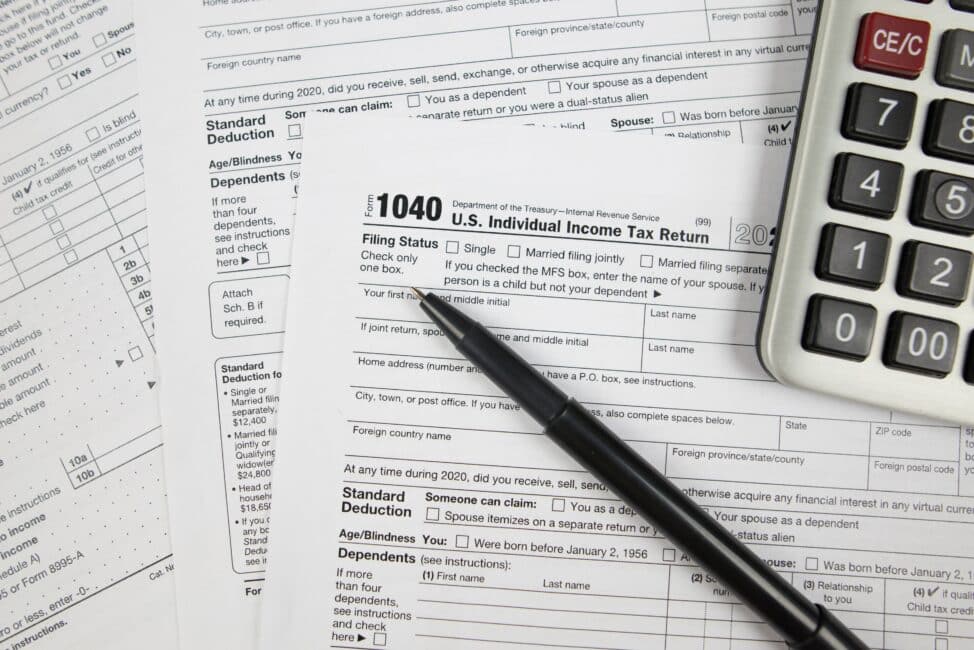 Tax forms, a pen, and a calculator on a table