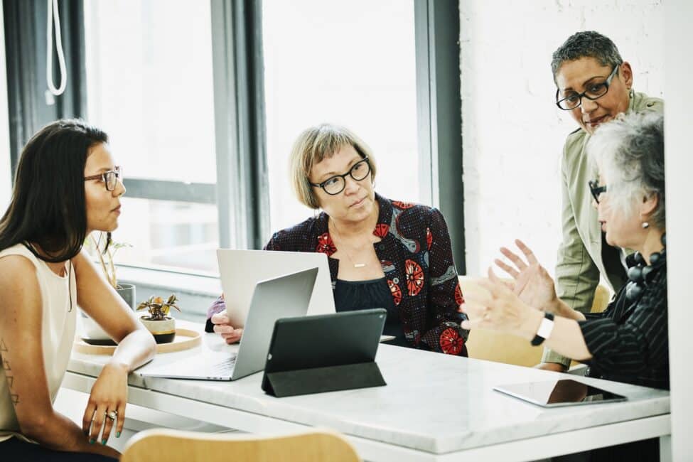 Senior businesswoman leading project discussion with colleagues in creative office